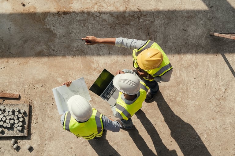 Team of engineers discussing blueprint at construction site