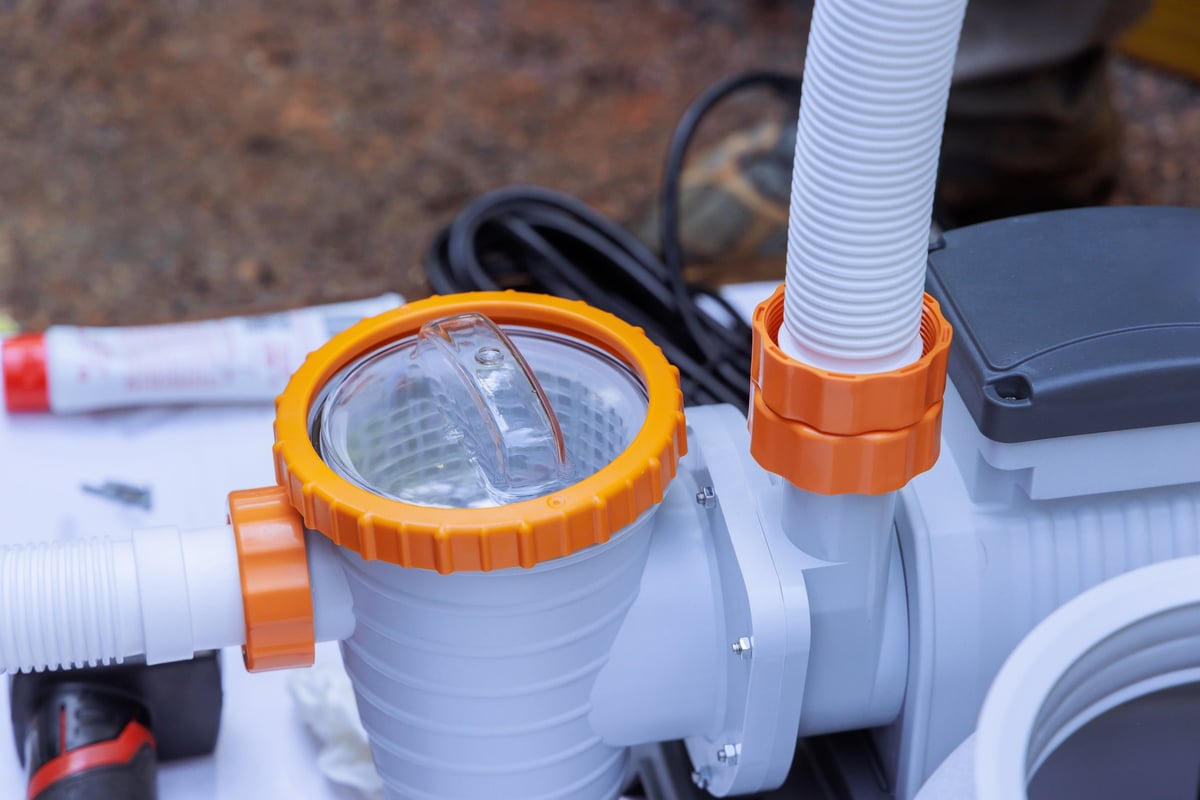 Worker assembles pool pump outdoors