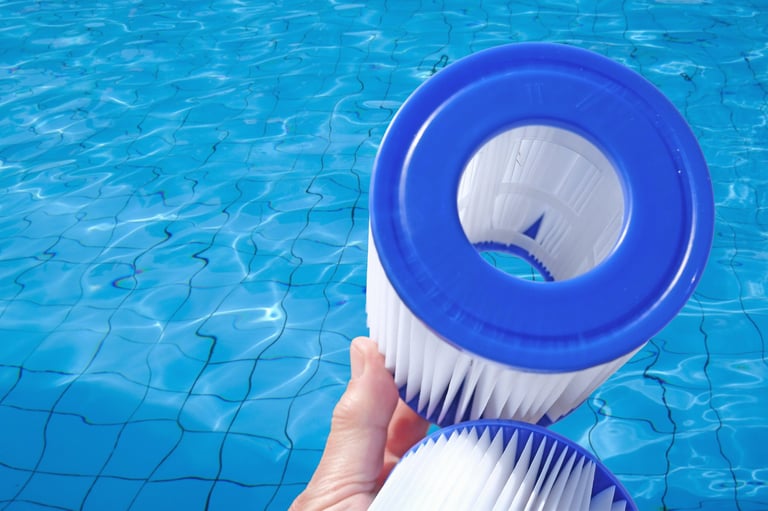 Reusable pool cartridge filters in a human hand on pool water backdrop. Cleaning and maintenance, water filter replacement.