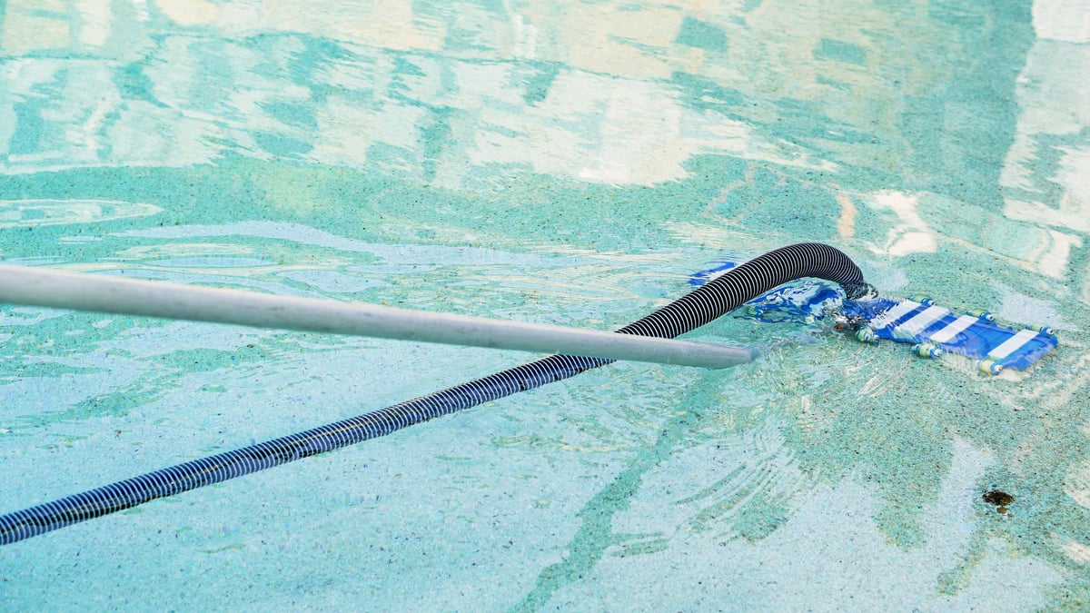 Hotel staff clean the swimming pool in the morning