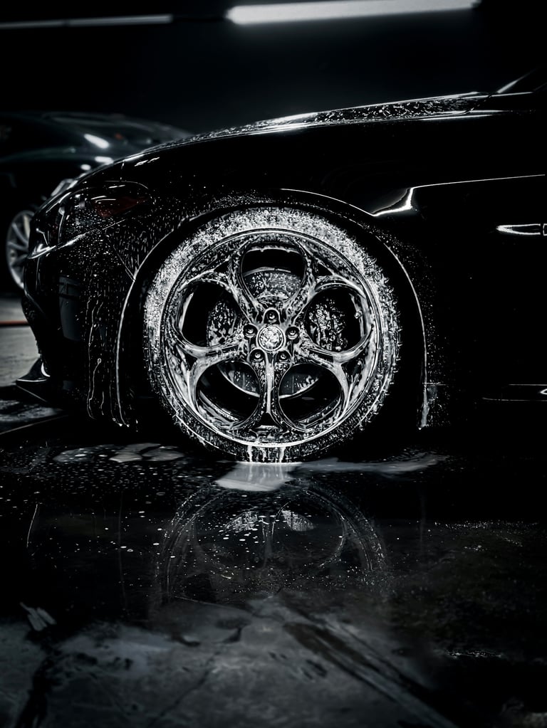 Close-up of wet car wheel and tire with intricate alloy rim design